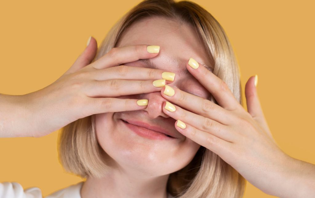 ragazza con occhi coperti sorride